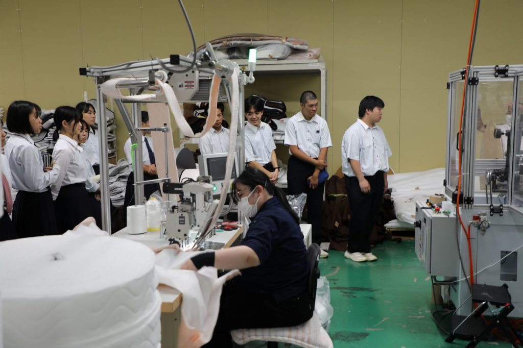 職人の縫製作業を真剣な表情で見つめる生徒さんたち